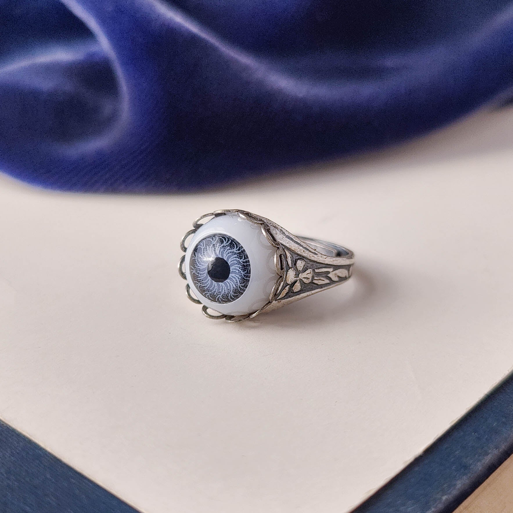 antiqued silver victorian gothic adjustable otherworldly lovecraft cocktail ring with a light blue doll's evil eye.