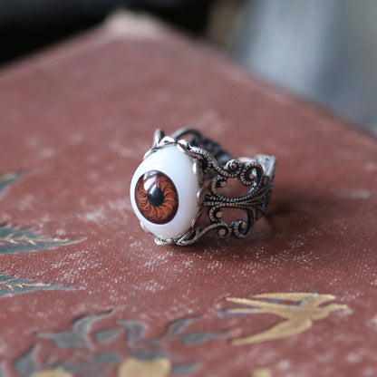 vintage style antiqued silver adjustable filigree ring with a brown oval doll eye in autumn academia style