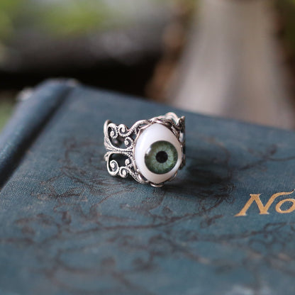 vintage style antiqued silver resizeable filigree ring with a green oval doll's eye in victorian gothic style