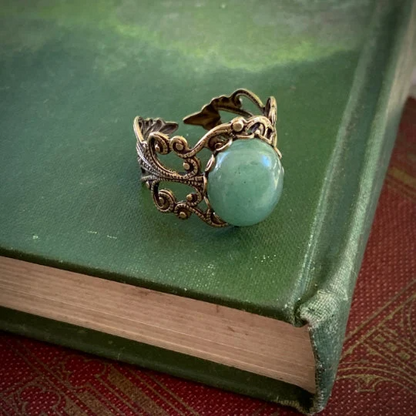 Antiqued brass filigree adjustable ring with oval green aventurine stone by ragtrader vintage.