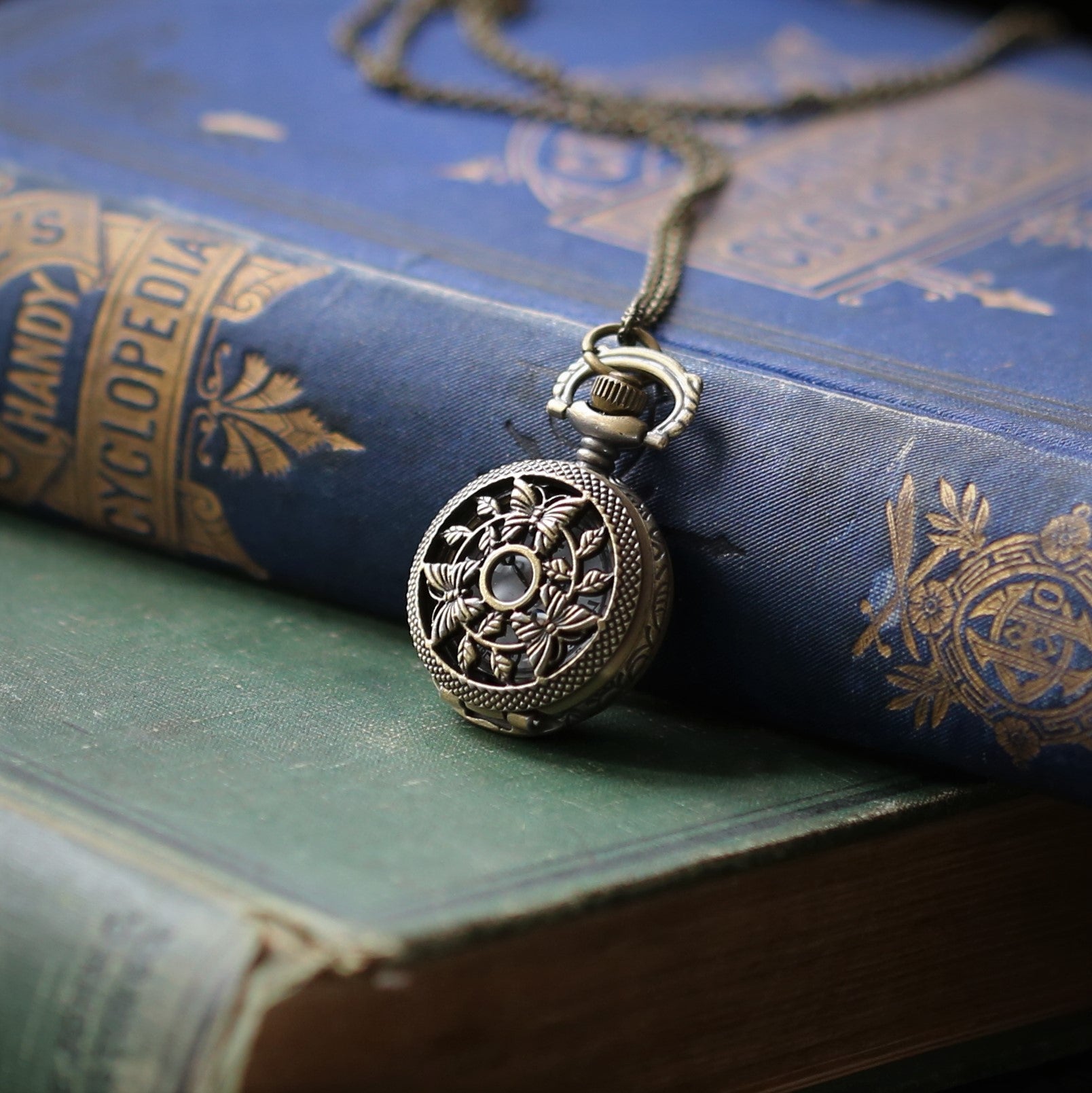 antiuqed brass wearable pocket watch necklace with three butterflies. Battery operated.