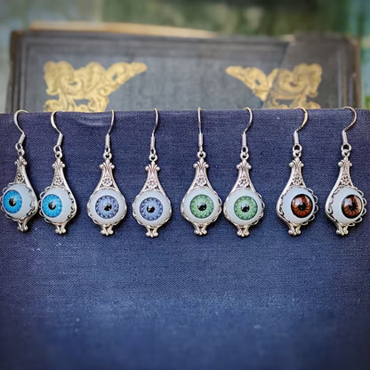 Antiqued silver vintage style drop evil eye earrings with blue green and brown dolls eyes.