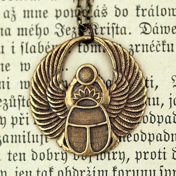 Antiqued brass scarab beetle pendant on a simple chain. Pendant is in a circular Art Deco design.