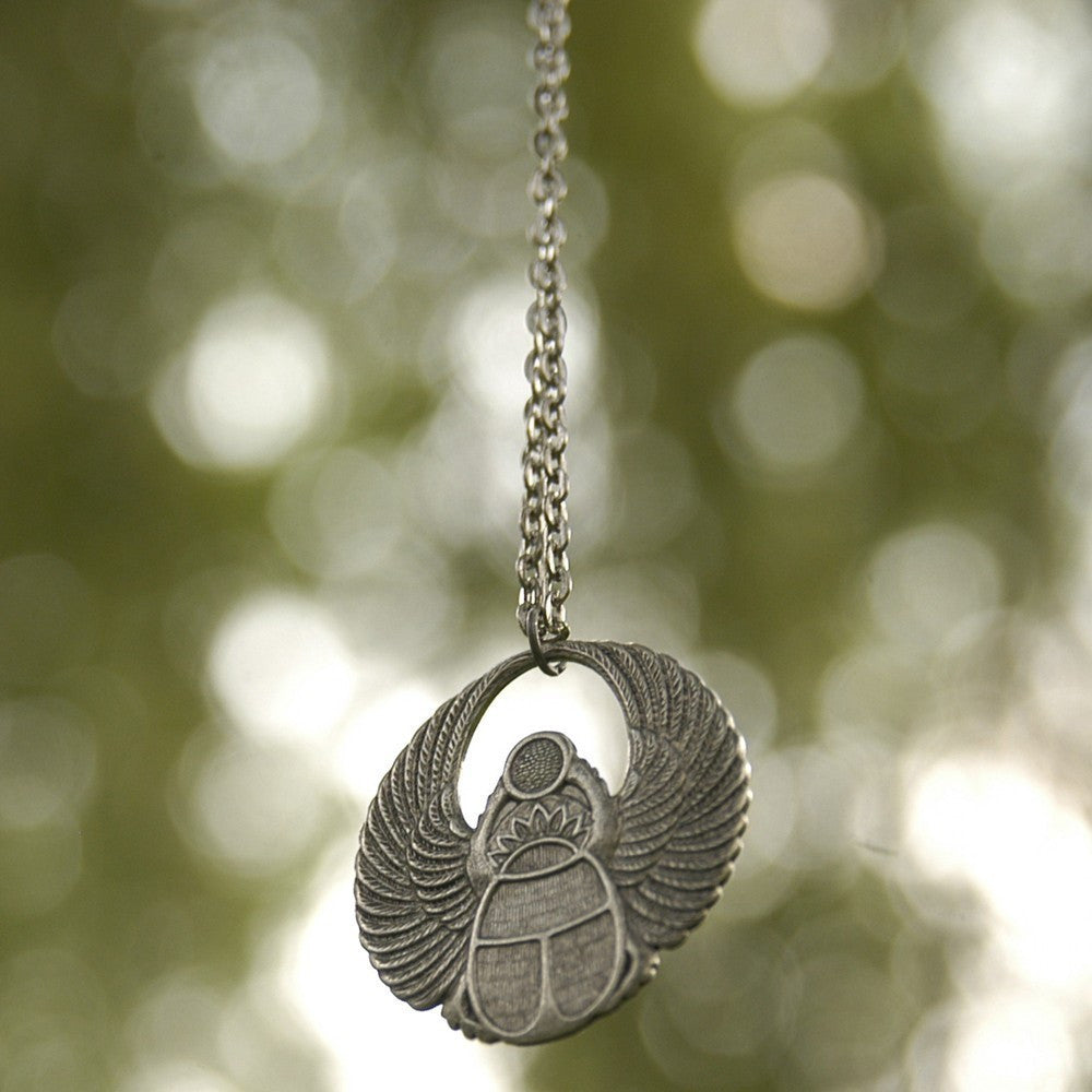 Antiqued silver scarab beetle pendant on a simple chain. Pendant is in a circular Art Deco design.