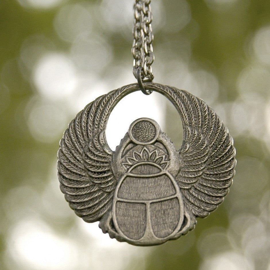 Antiqued silver scarab beetle pendant on a simple chain. Pendant is in a circular Art Deco design.