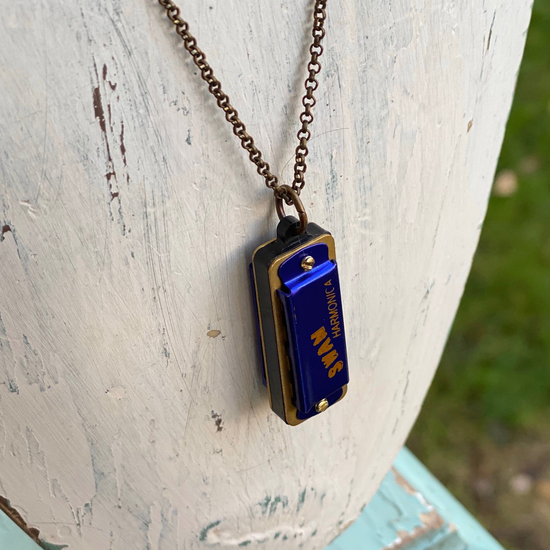 Miniature blue SWAN harmonica on a brass chain.