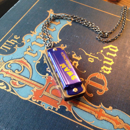 Miniature blue SWAN harmonica on a brass chain.
