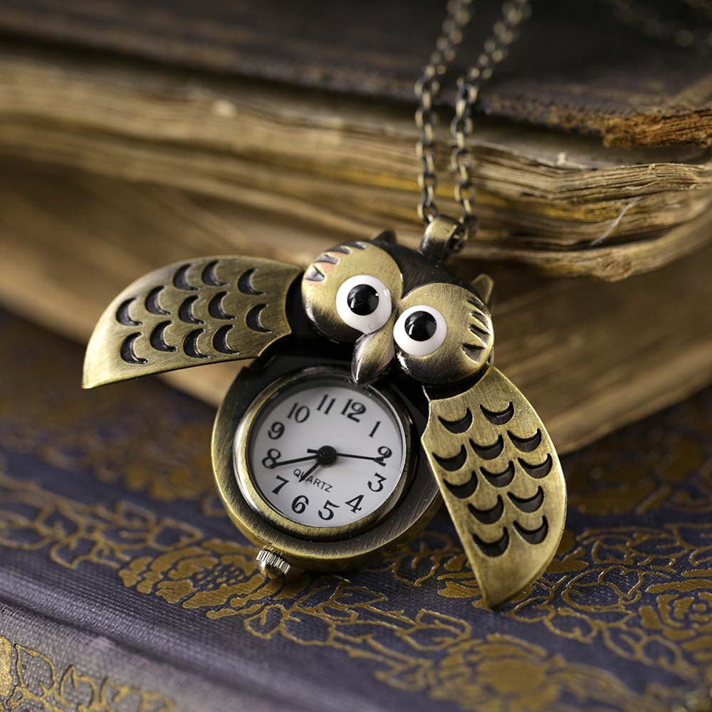 A bronze owl-shaped watch necklace with a quartz face. This watch is displayed open, with the owl's wings open to show the watch face.
