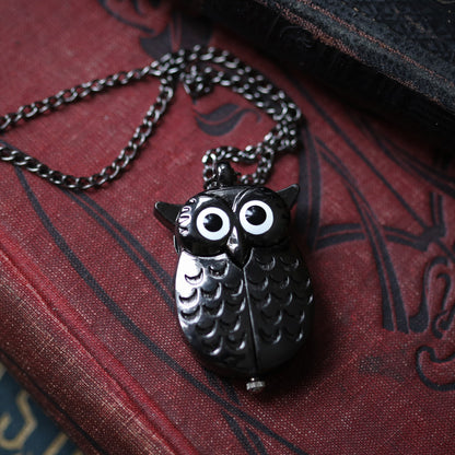 A gun metal owl-shaped watch necklace. This watch is closed with the owl's wings covering the watch face.