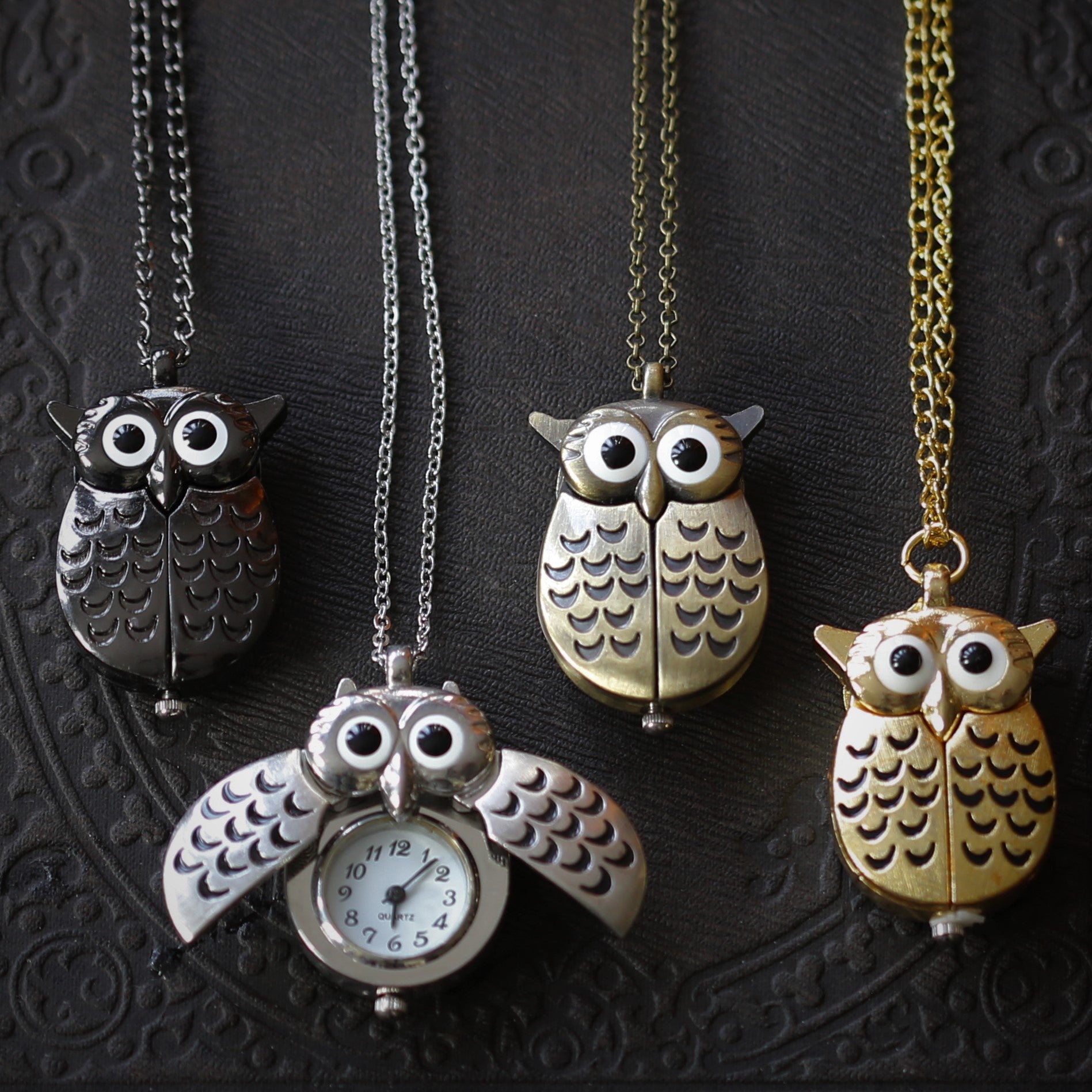 Four owl-shaped watch necklaces displaying the different metal options: Gun Metal, Silver, Bronze, and Gold.