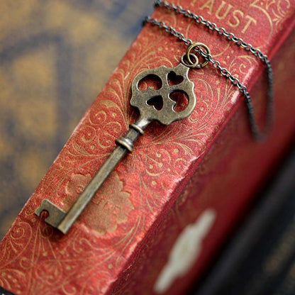 Antiqued brass key necklace. Head of the key has four cutouts, two of which are hearts.
