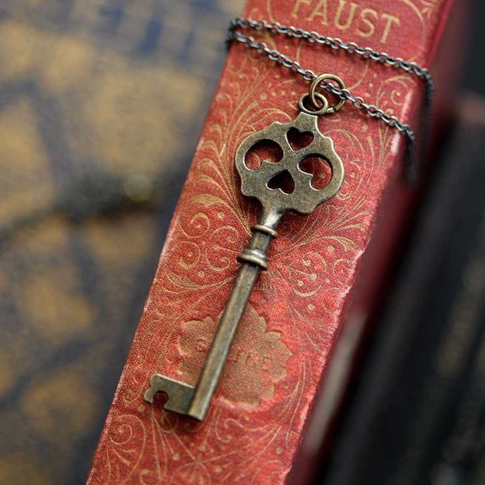 Antiqued brass key necklace. Head of the key has four cutouts, two of which are hearts.