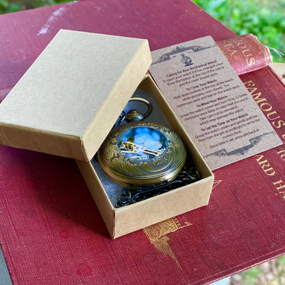Antiqued brass mechanical pocket watch with zodiac symbols around the lid displayed in a box.