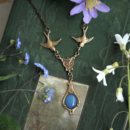 Antiqued brass vintage-style blue agate drop pendant featuring birds in a fairy core style.