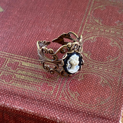 Antiqued brass adjustable filigree ring with black and white lady cameo.