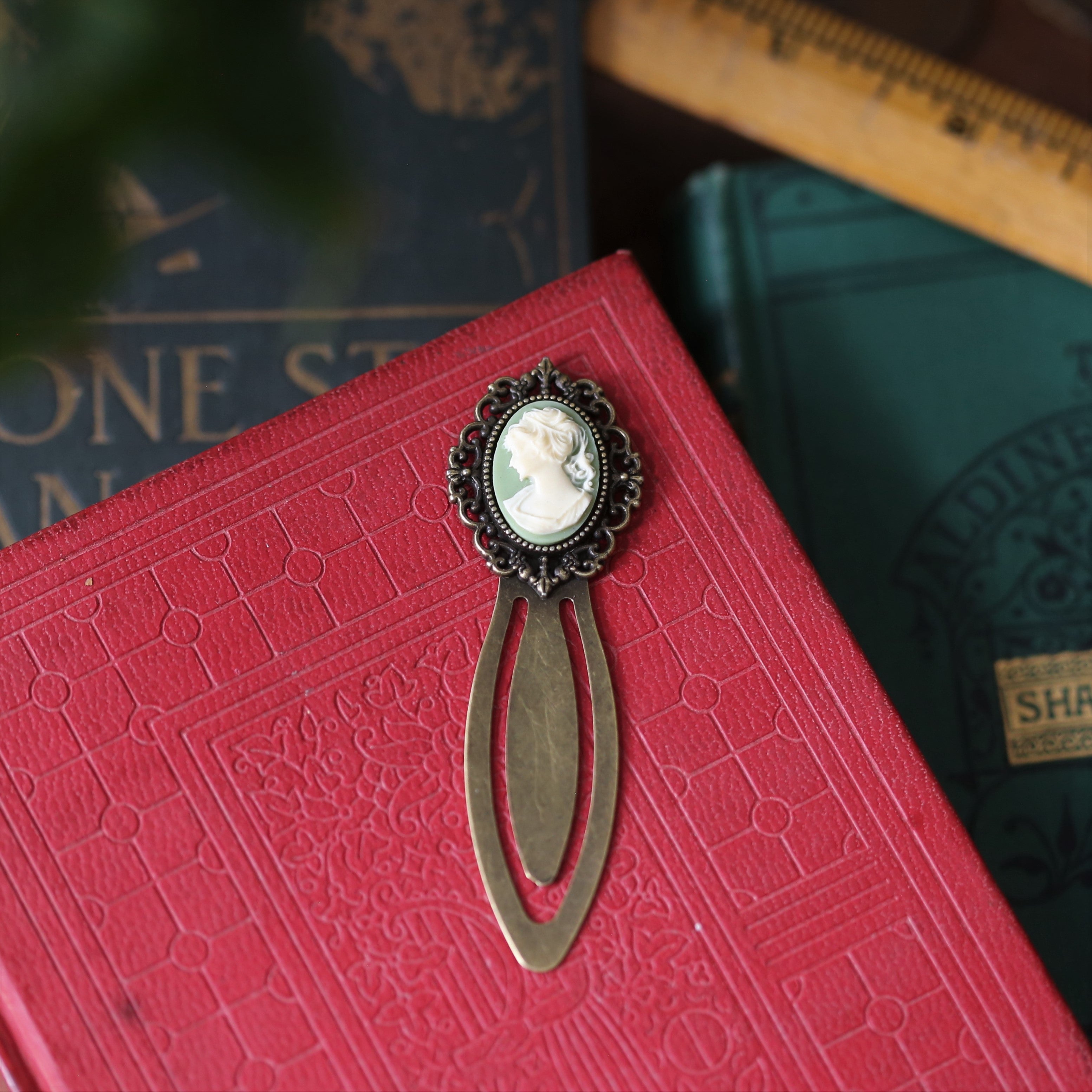 antiqued brass modern vintage inspired oval cameo clip bookmark with green background and white lady profile cameo a perfect gift for librarians.