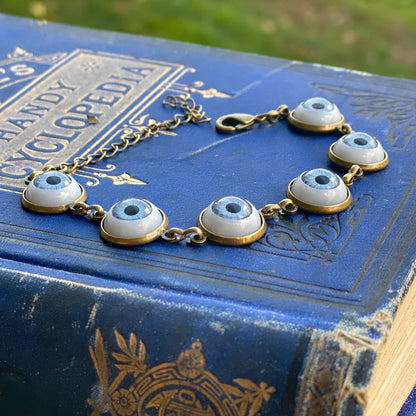 antiqued brass modern style adjustable blue evil eye warding charm dangle bracelet.