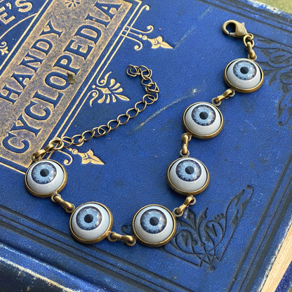 antiqued brass Victorian gothic style adjustable blue evil eye cabochon dangle bracelet to ward off envy.