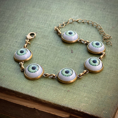 antiqued brass Victorian gothic style adjustable green evil eye cabochon dangle bracelet.