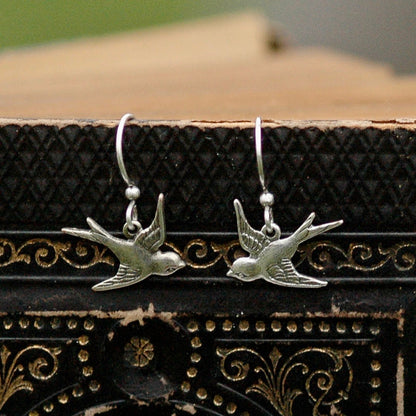 Silver earrings with flying bird charms