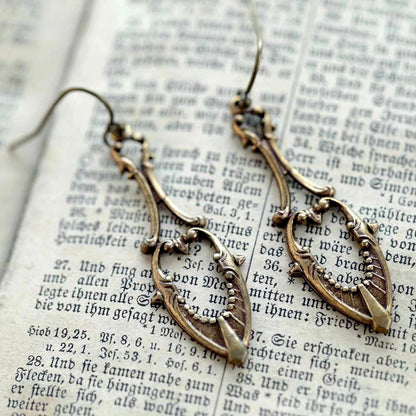 Antiqued brass drop earrings with a art deco cutout design.