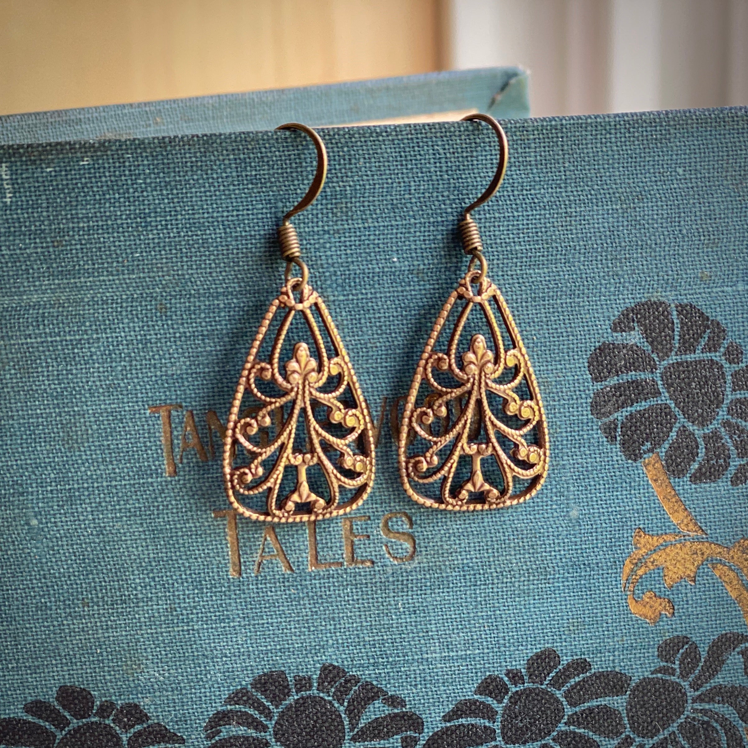 Antiqued brass drop earrings with a tendrils cutout design.