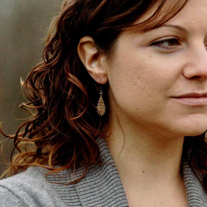 Antiqued brass drop earrings with a detailed filigree design.