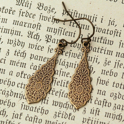 Antiqued brass drop earrings with a detailed filigree design.