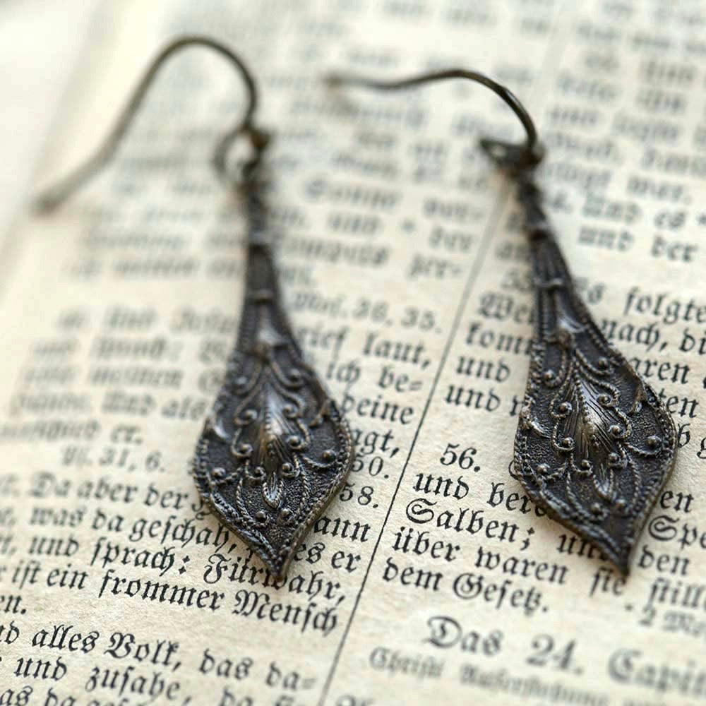 Dark antiqued brass drop earrings with a detailed leaf filigree design.
