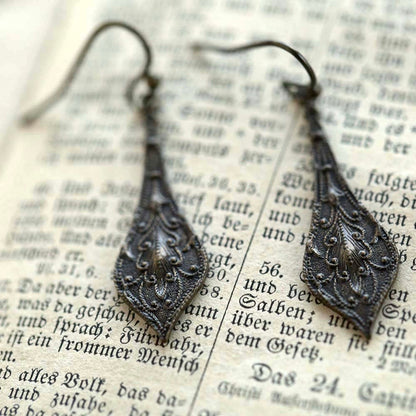 Dark antiqued brass drop earrings with a detailed leaf filigree design.