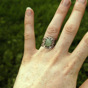 Antiqued silver adjustable vintage style filigree stone ring with green oval mineral.