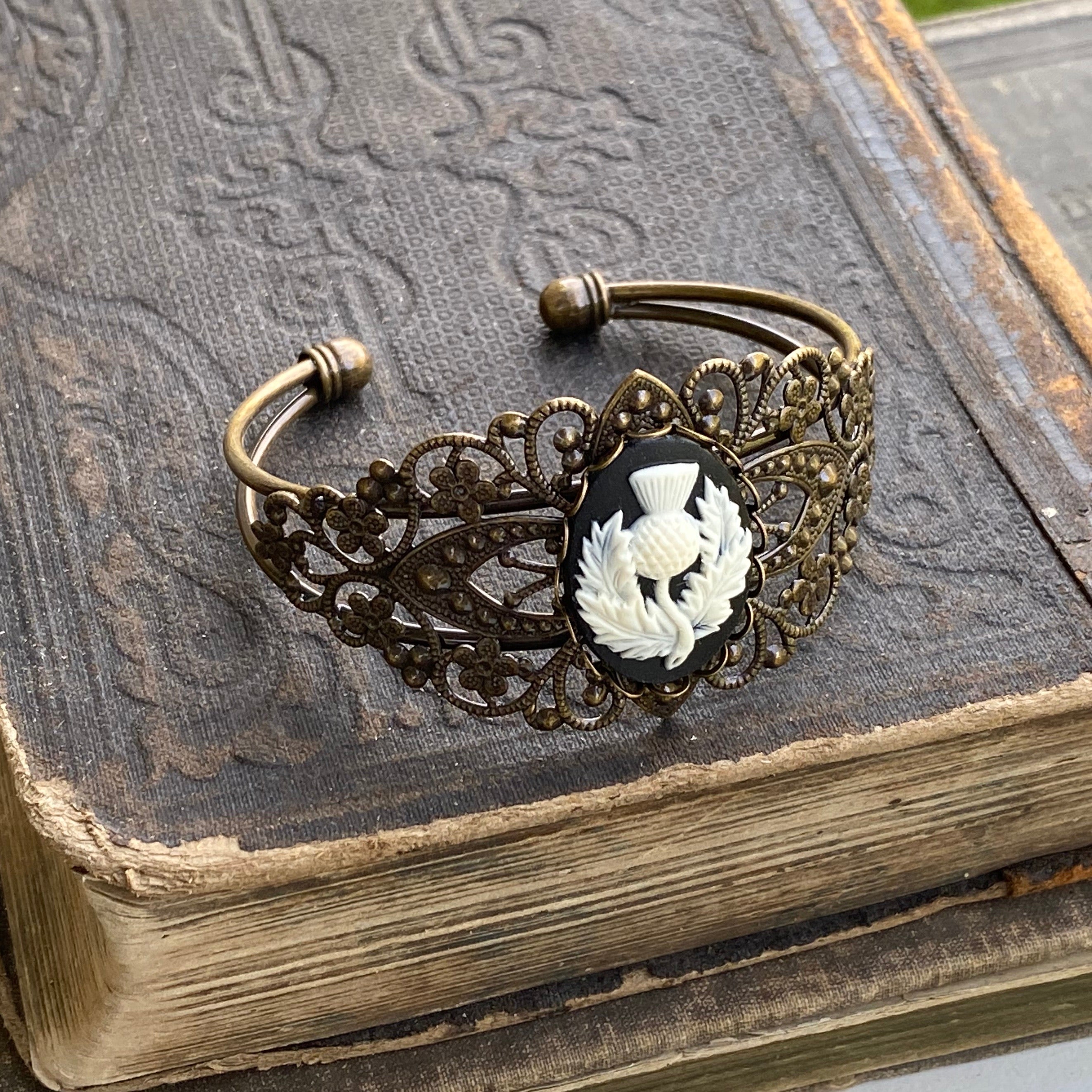 Antiqued brass bronze tone vintage style Victorian adjustable bracelet cuff with a black and white Scottish thistle cameo.