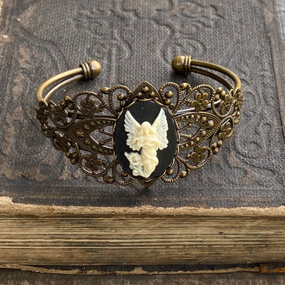 Antiqued brass bronze tone vintage style Victorian adjustable bracelet cuff with a black and white angel cameo.