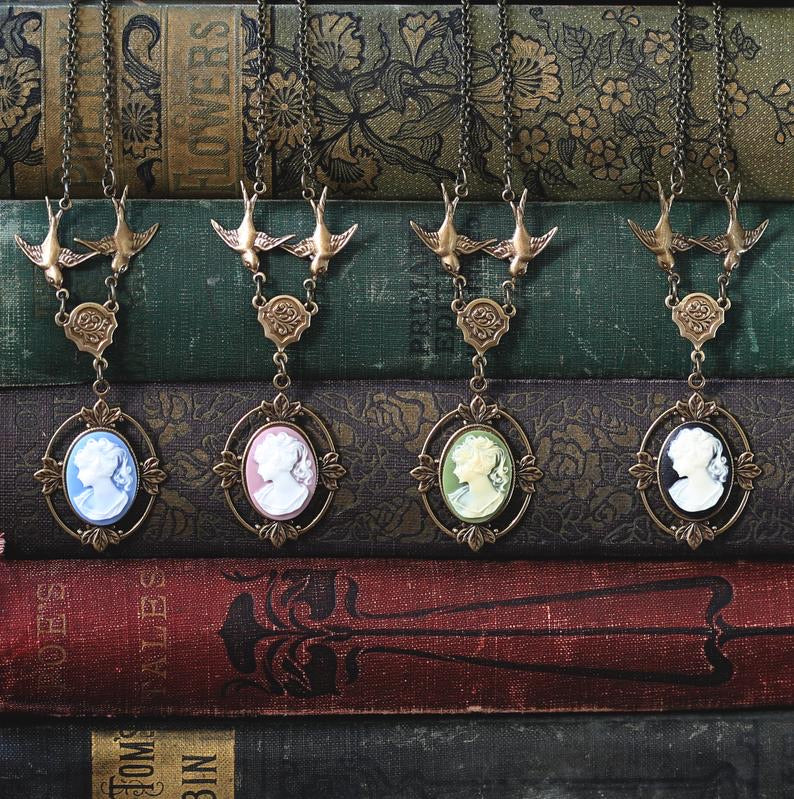 Antiqued brass Victorian lady cameo necklaces on chains with birds. Blue, pink, green, and black cameo options.