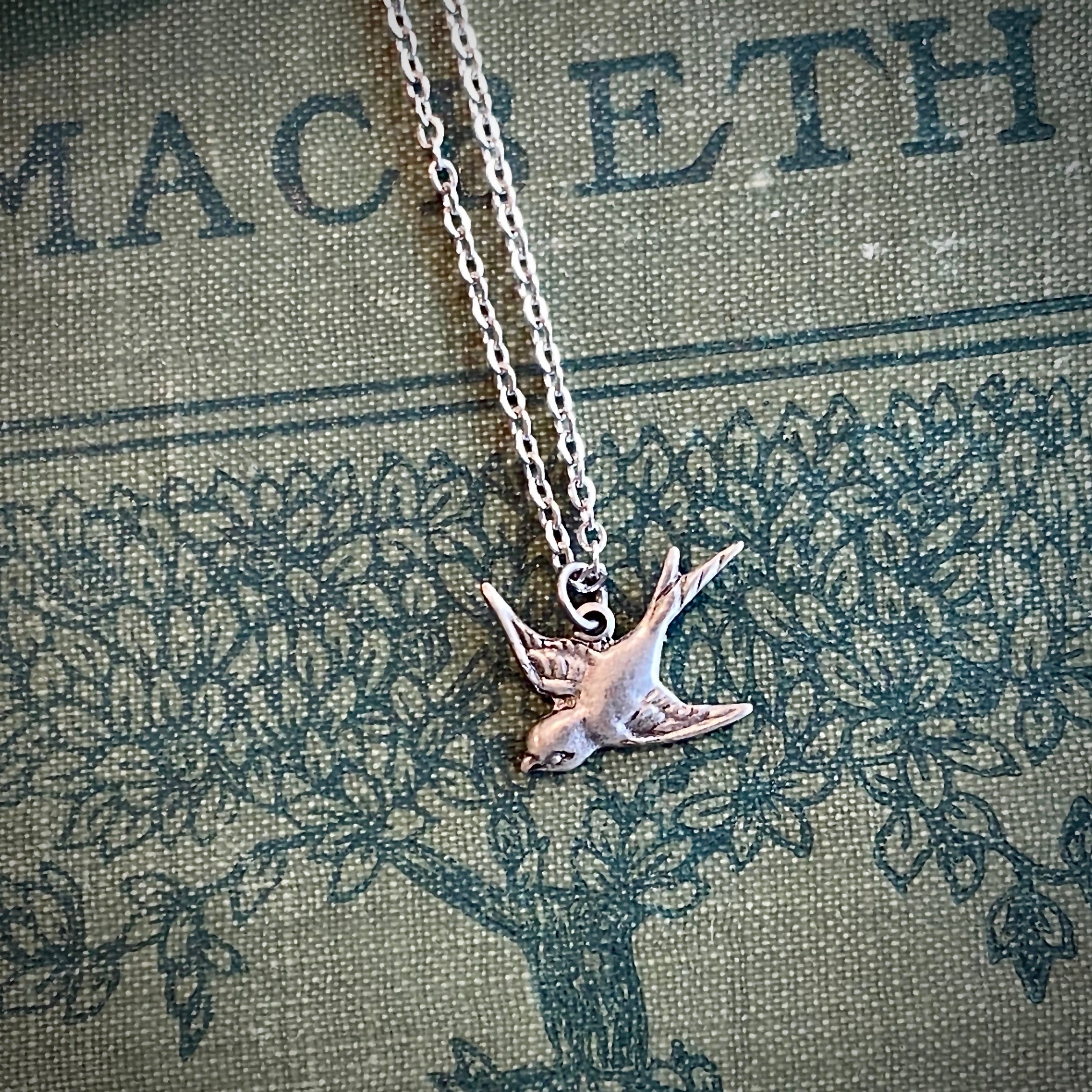 Silver necklace with a flying bird charm