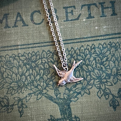 Silver necklace with a flying bird charm