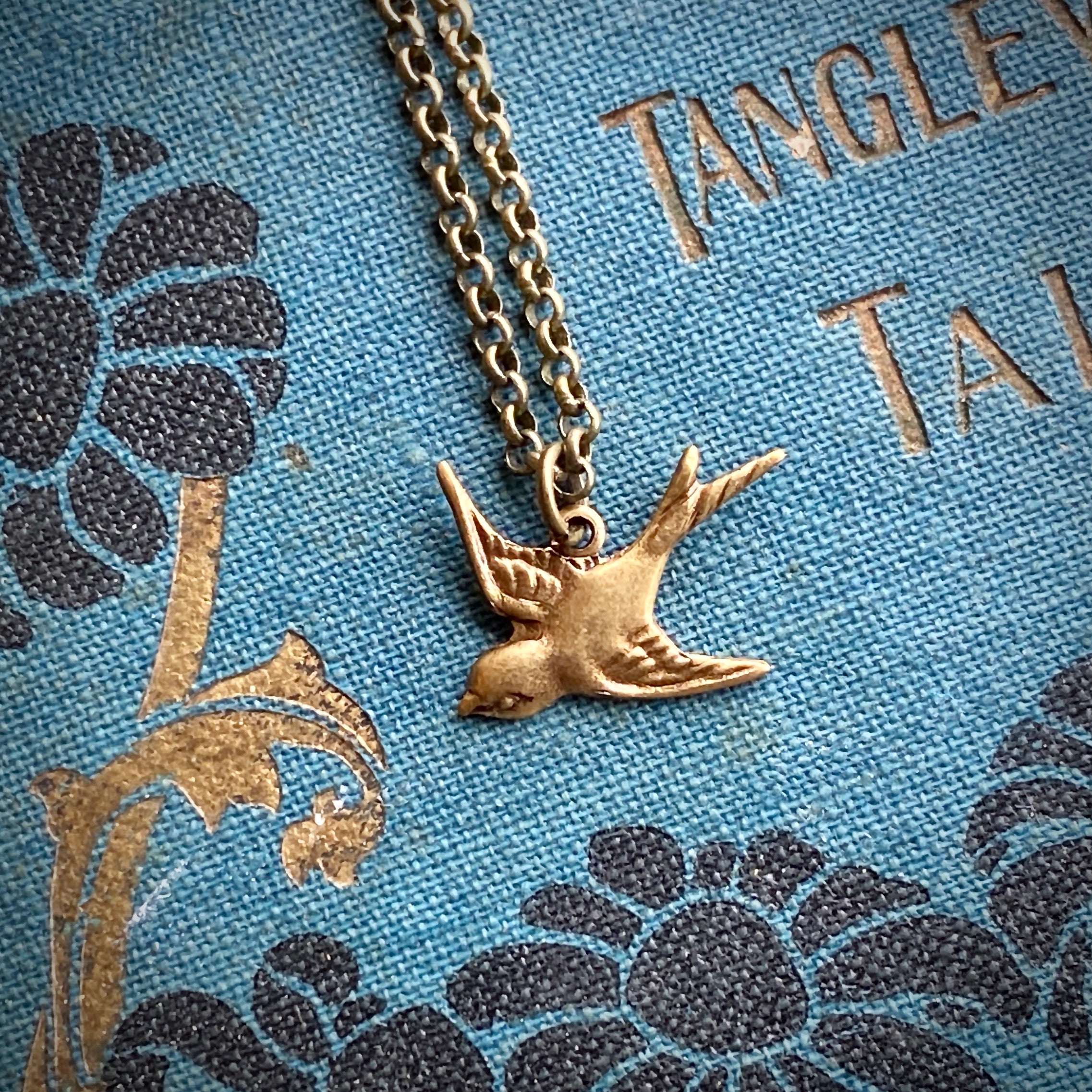 Brass necklace with a flying bird charm
