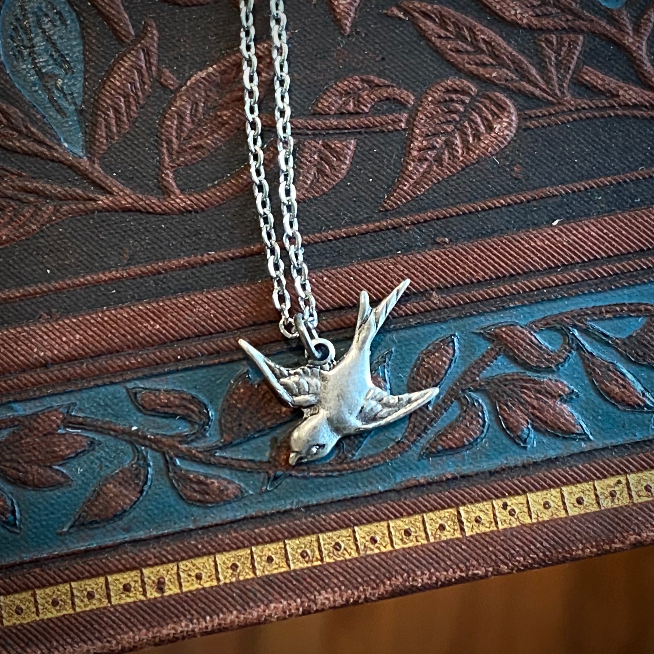 Silver necklace with a flying bird charm
