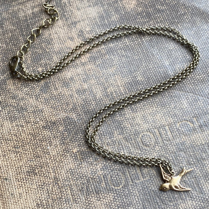 Silver necklace with a flying bird charm