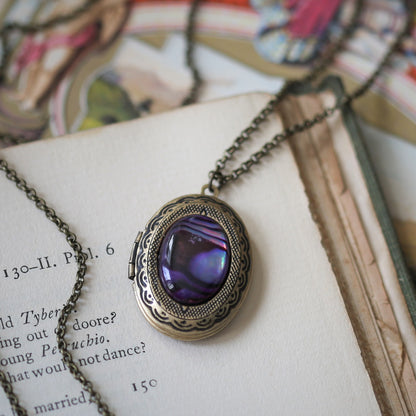 antiqued brass vintage style oval locket with a purple seashell cabochon in boho aesthetic a thoughtful gift for a love one