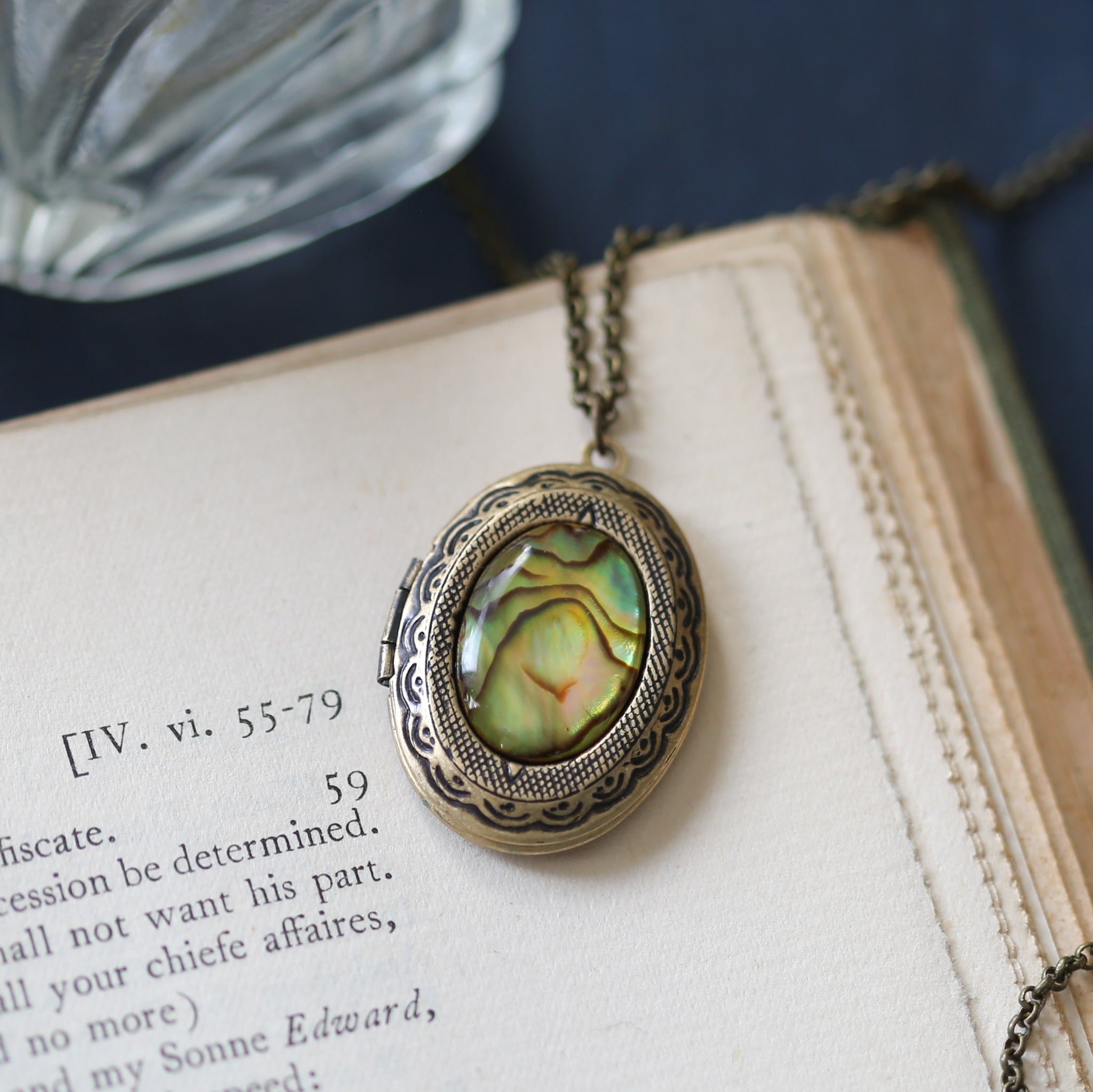 antiqued brass vintage style oval locket with a yellow green seashell cabochon in cottagecore aesthetic a meaningful gift for a love one