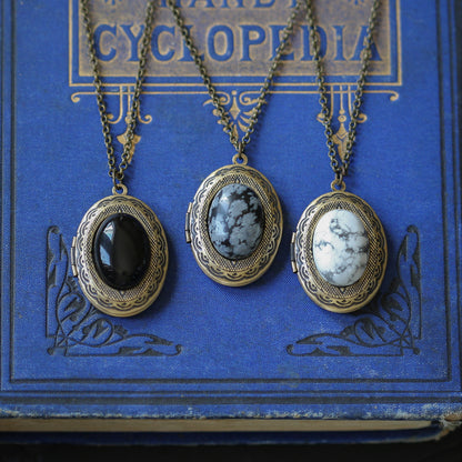 antiqued brass victorian goth snowflake obsidian onyx or howlite gray black and white semi precious oval stone set on a locket making a great gift for oved one.