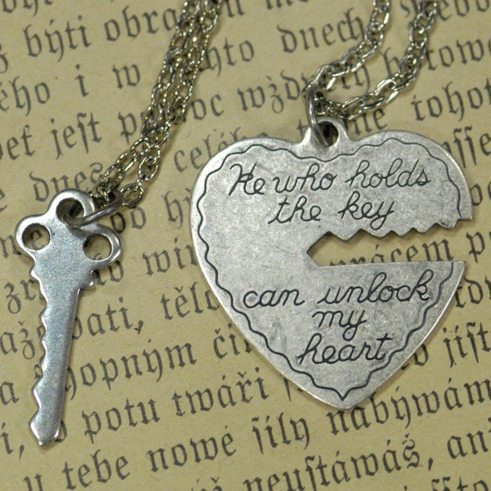 Antiqued silver necklaces. One with a key pendant and the other with a heart-shaped pendant with a key-shaped cutout.