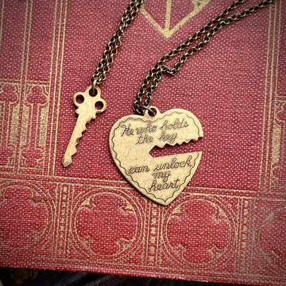 Antiqued brass necklaces. One with a key pendant and the other with a heart-shaped pendant with a key-shaped cutout.