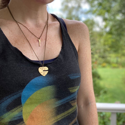 Antiqued brass necklaces. One with a key pendant and the other with a heart-shaped pendant with a key-shaped cutout.