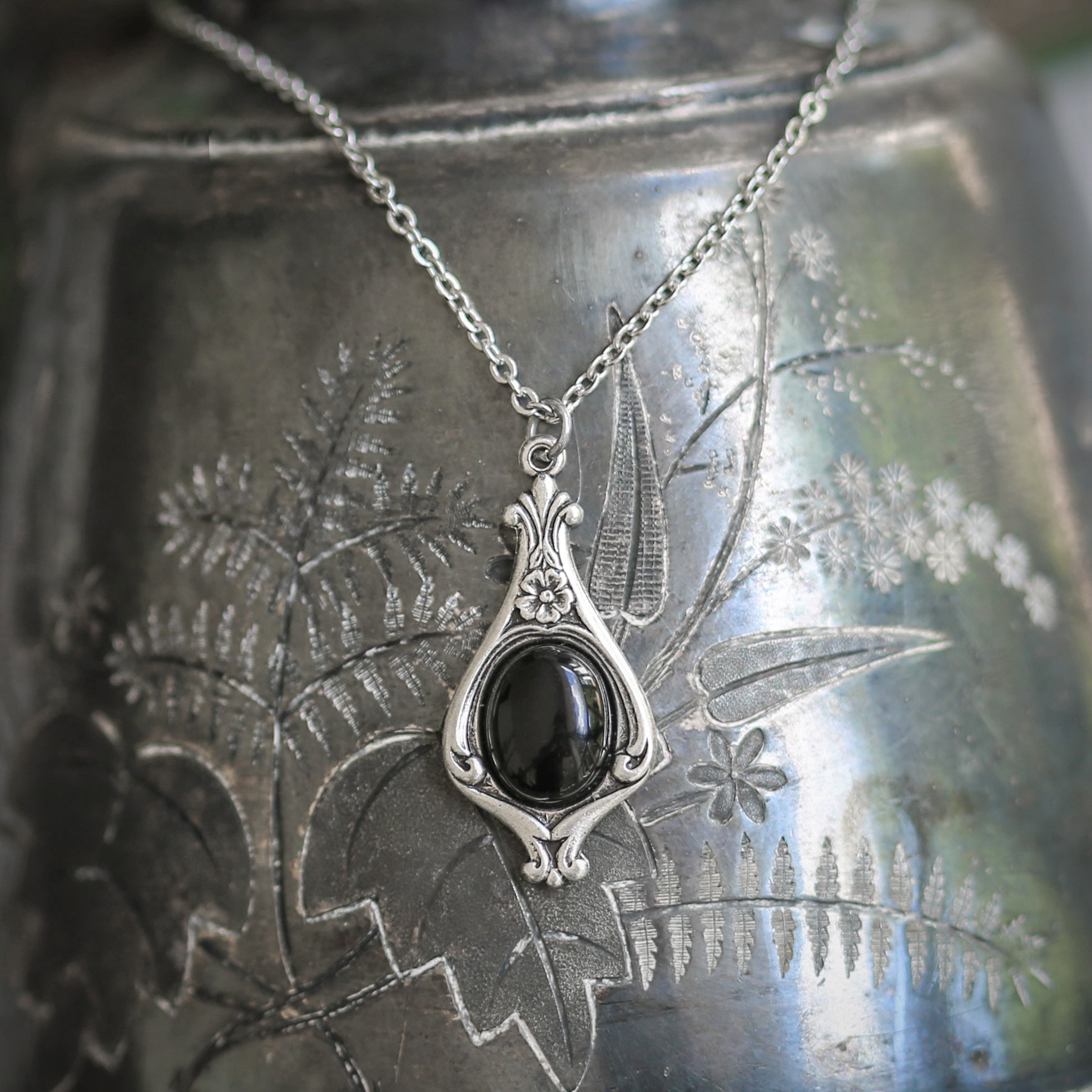 Antiqued silver vintage inspired small egirl aesthetic necklace with a dainty black onyx stone on a mini floral drop setting.