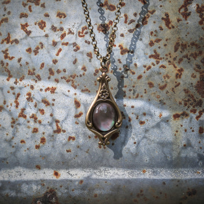 Antiqued brass vintage inspired small bloomcore aesthetic necklace with a dainty gray paua shell on a mini floral drop setting.