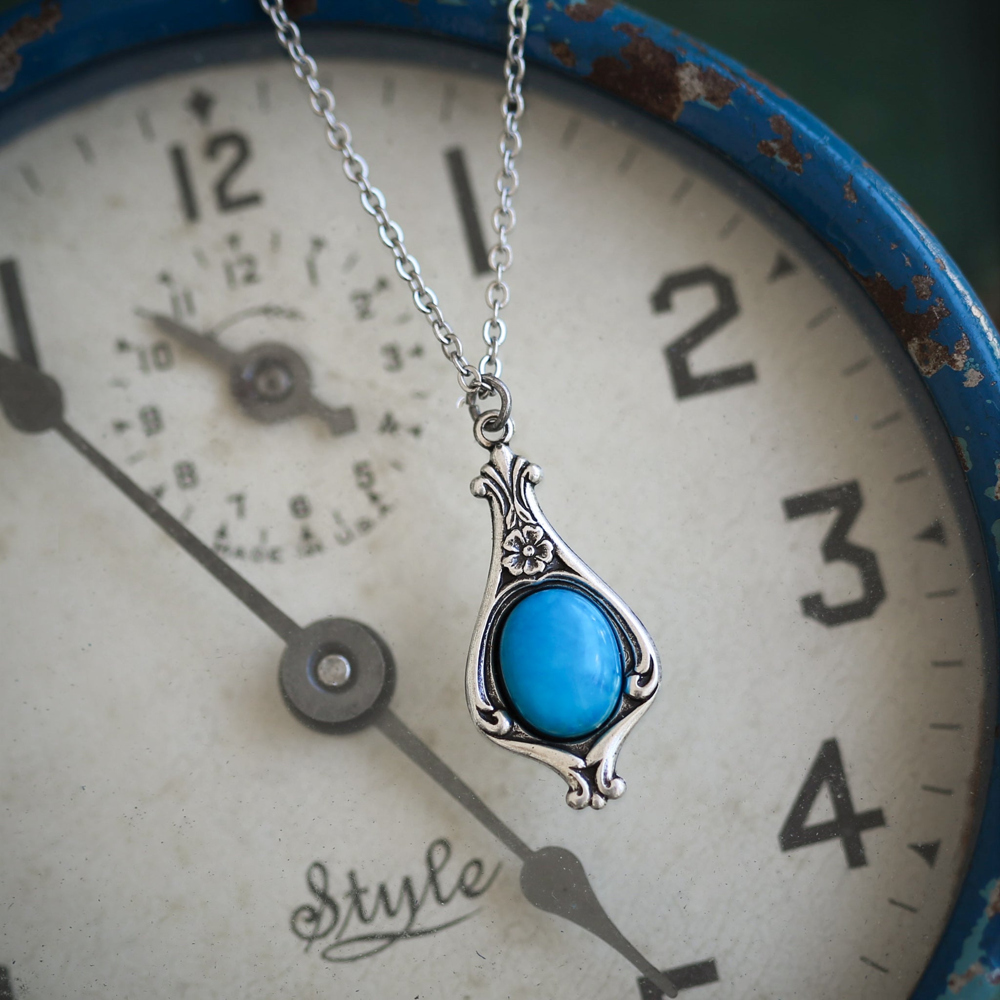 Antiqued silver vintage-inspired small pastel academia aesthetic necklace with a dainty blue howlite stone on a mini floral drop setting.