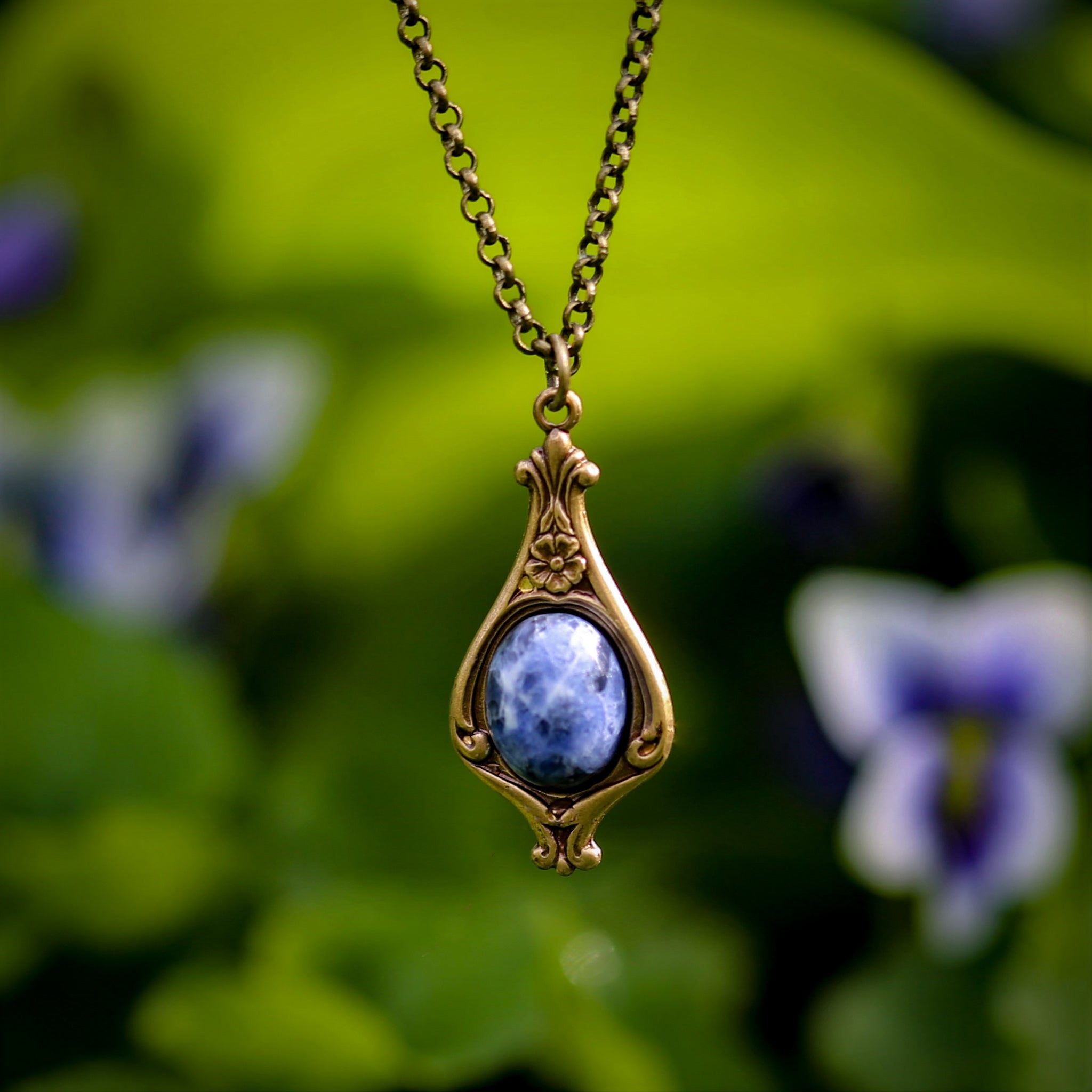 Antiqued brass vintage-inspired small lunarpunk aesthetic necklace with a dainty blue sodalite stone on a mini floral drop setting.