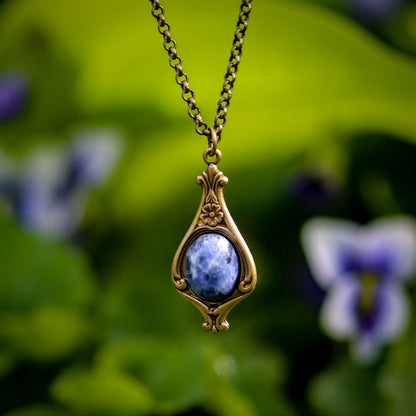 Antiqued brass vintage-inspired small lunarpunk aesthetic necklace with a dainty blue sodalite stone on a mini floral drop setting.